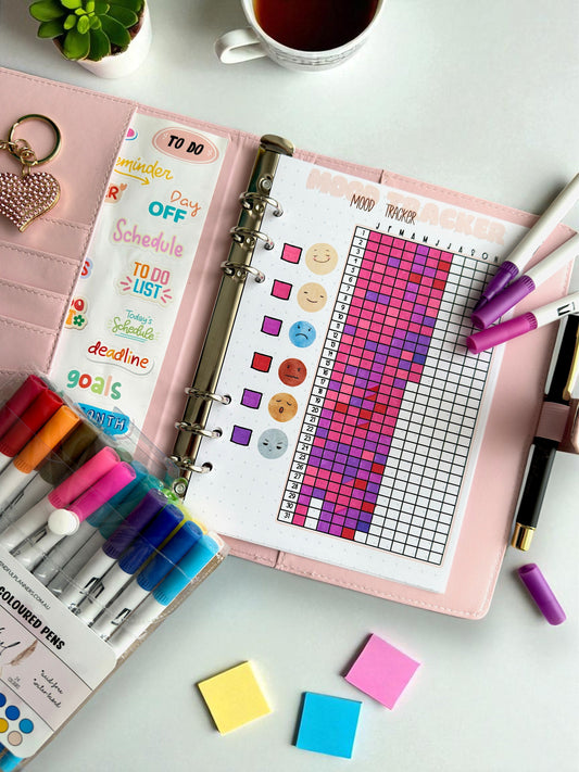 A soft-toned journal open to a pre-filled mood tracker page, styled with stationery items — perfect for anyone exploring a mental health journal or mood tracker journal routine.
