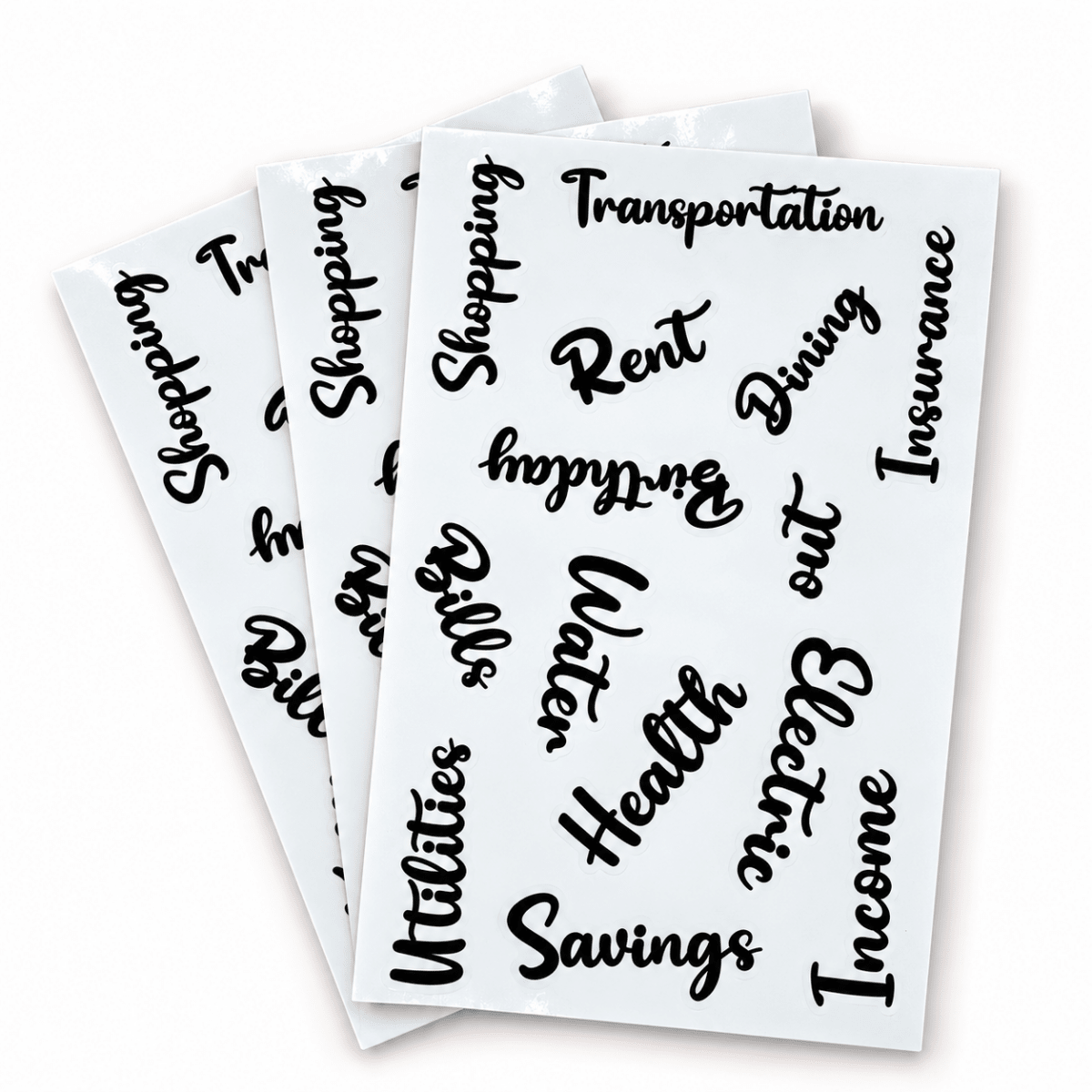 Three sheets of black script money-saving labels on a white background, featuring words like 'Shopping', 'Rent', 'Dining', 'Insurance', 'Utilities', 'Savings', and 'Income'.