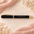 Black ballpoint pen with gold detail for journaling, on blush fabric