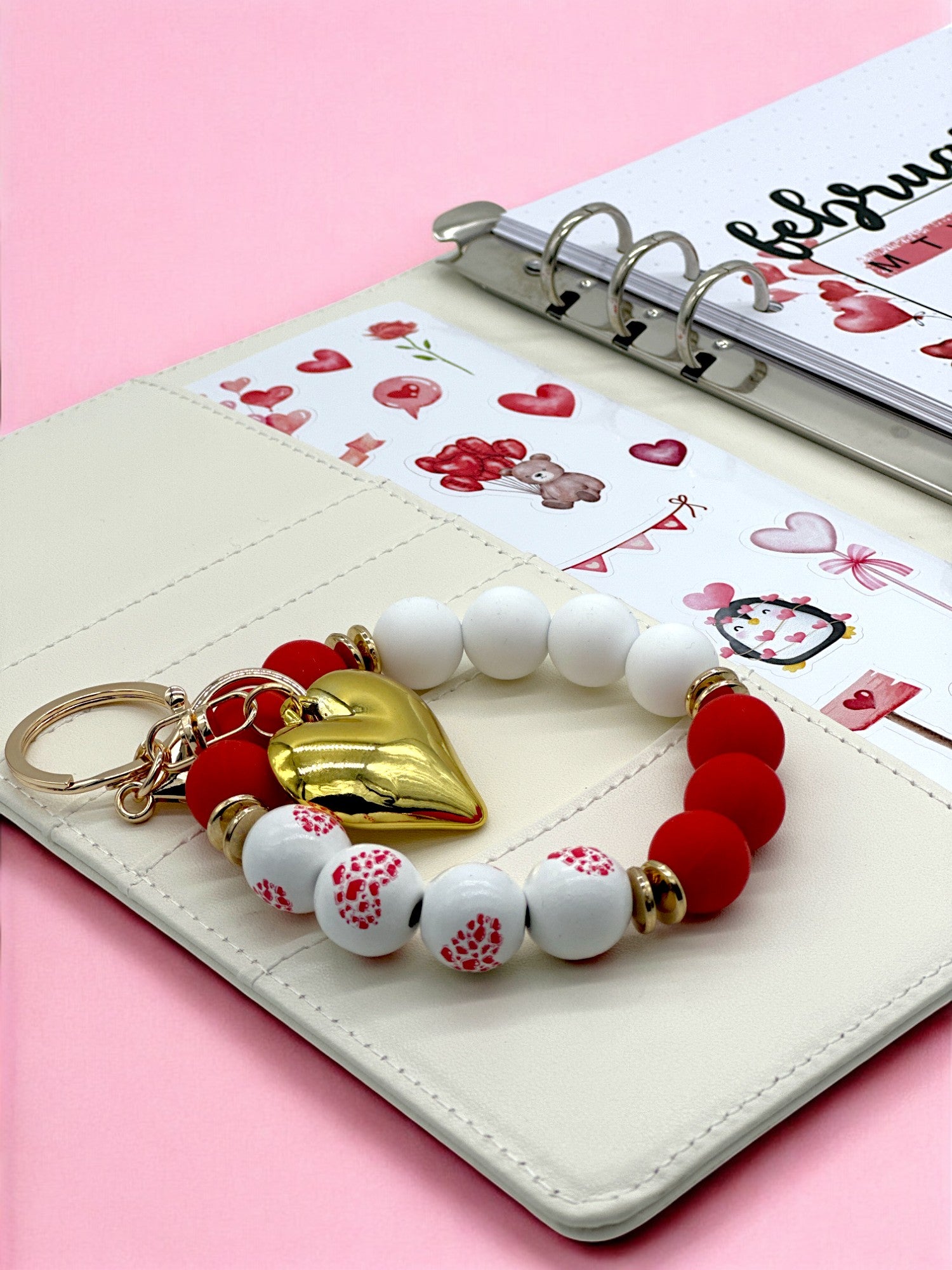 Red and white heart beaded bracelet keychain on a journal