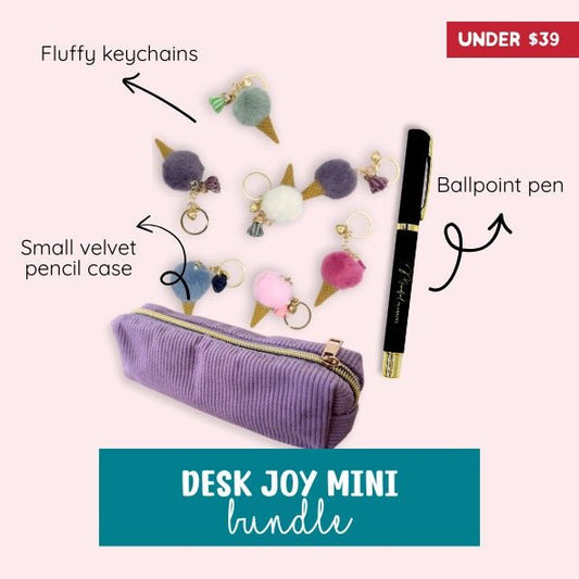 Desk Joy Mini bundle with fluffy keychains, small velvet pencil case, and ballpoint pen on a pink background.